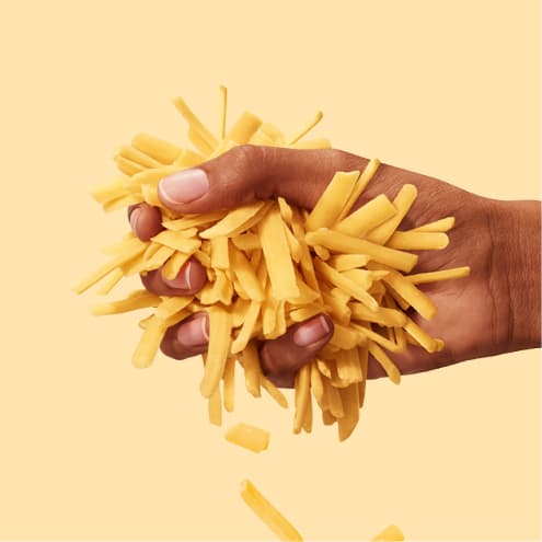 Hand holding Tillamook Cheddar Cheese Shreds